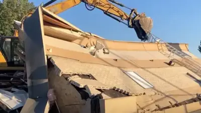 Demolizione edificio ruspa